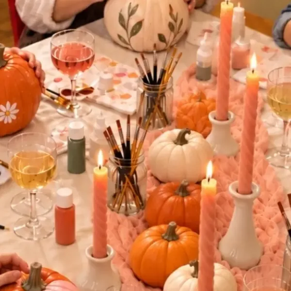 a row of orange and white pumpkins between candles on the table